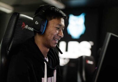Elev spelar e-sport med stora hörlurar och skrattar.