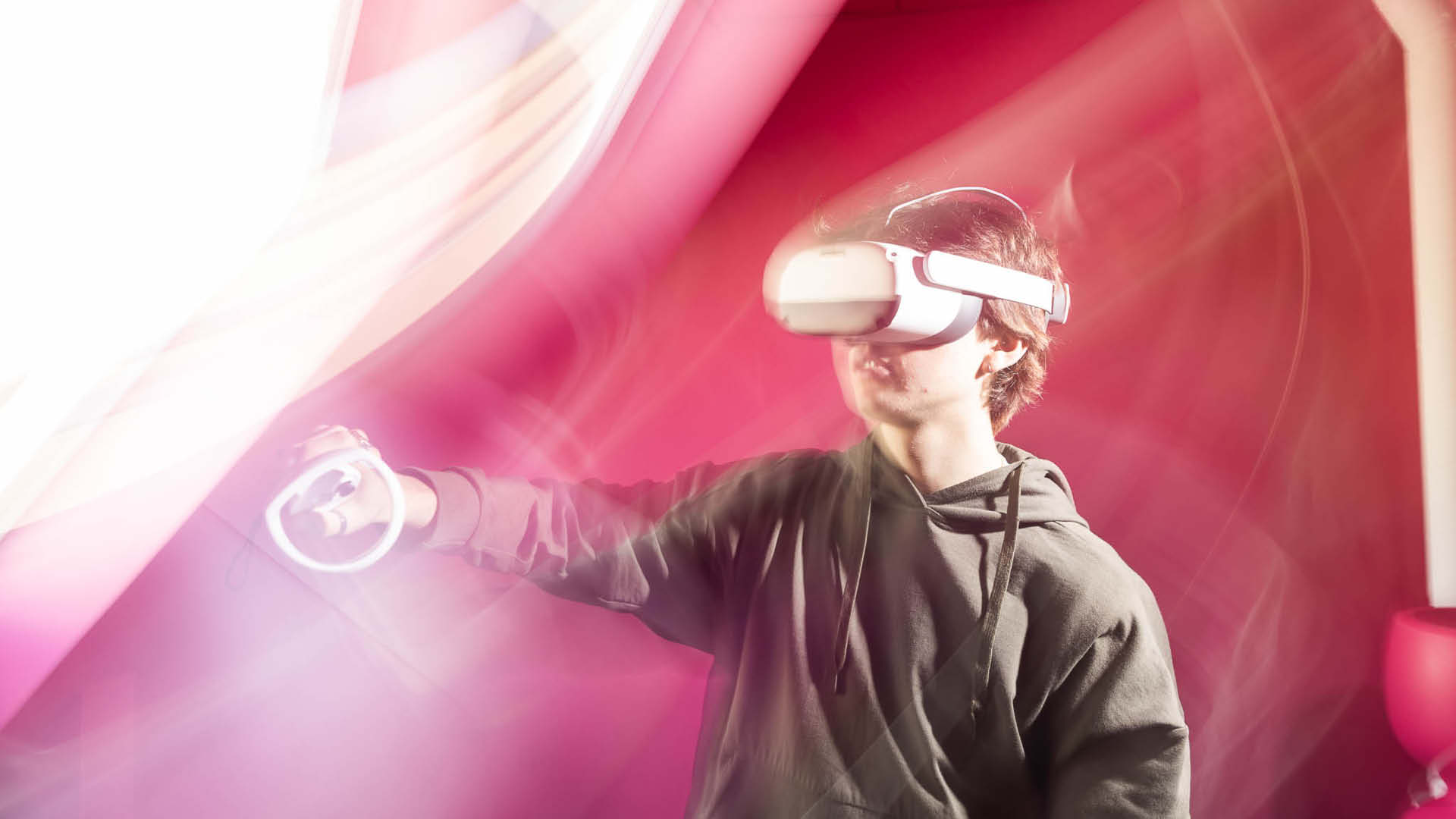 Elev med VR-headset spelar spel i ett rosa rum.