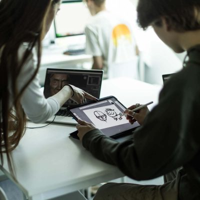 Två elever skissar i ett ritprogram på en ritplatta.