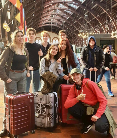 En grupp elever med resväskor på en tågstation.